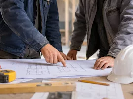 Handwerker beim Betrachten von Bauplänen