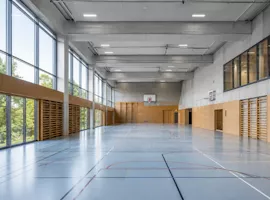 Grosse Turnhalle mit Holzsprossenwänden und Tageslicht