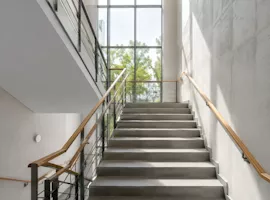 Helles Treppenhaus mit grossen Fenstern in einer Schule