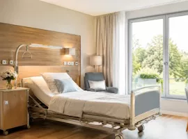 Modernes Patientenzimmer mit Pflegebett und Ausblick ins Grüne